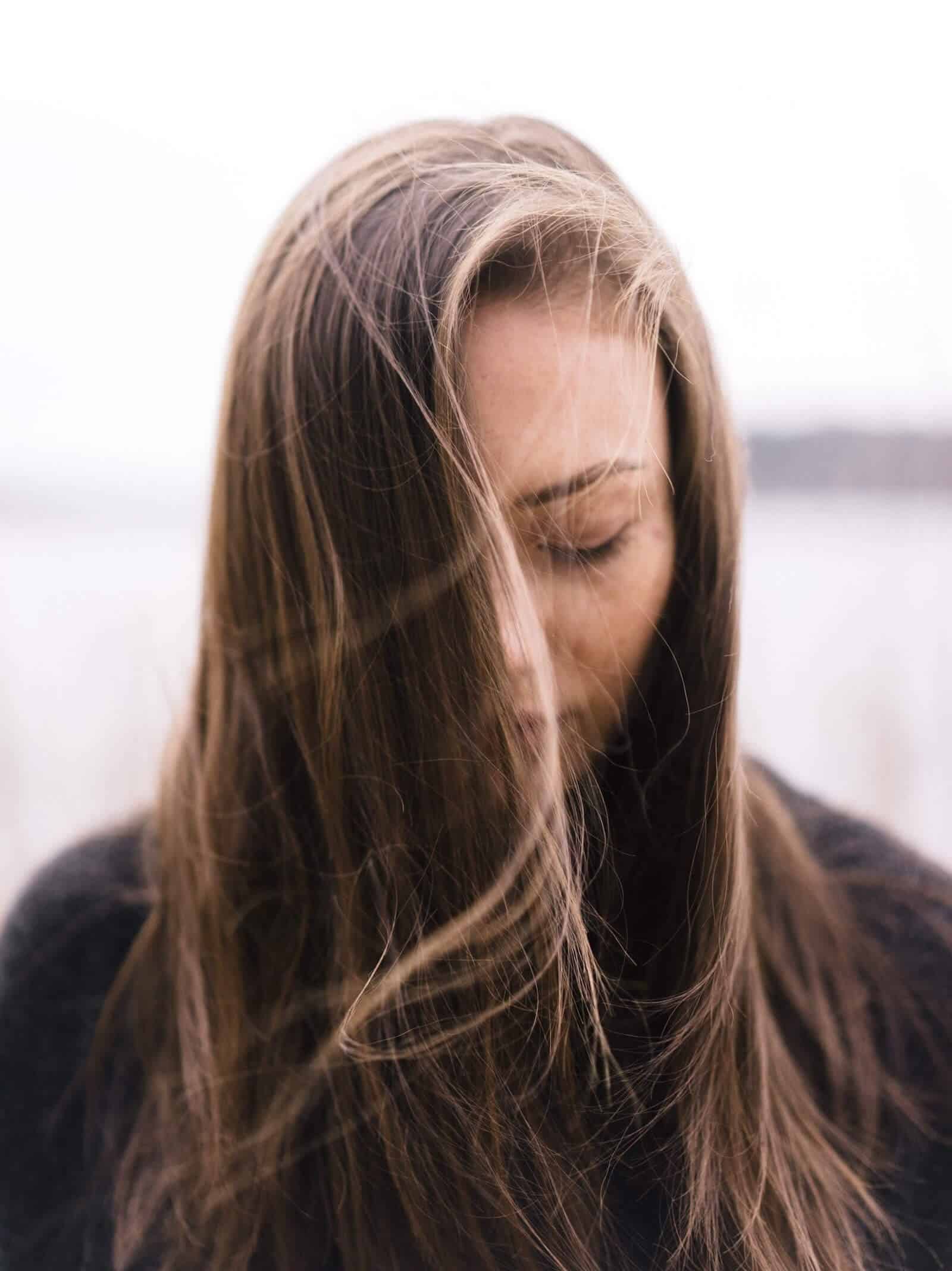 Woman with no expression on face, looking down