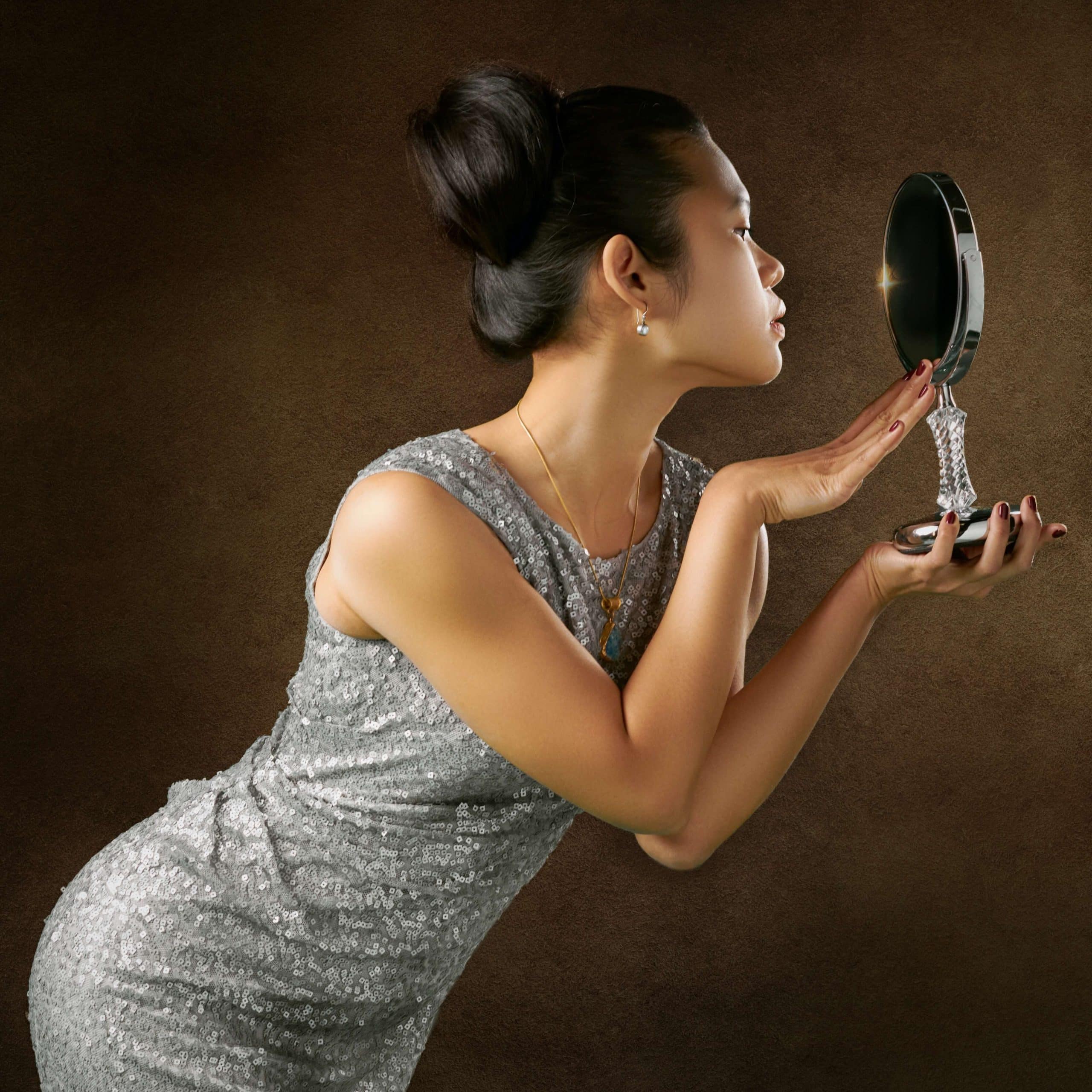 Maladaptive Schemas: Approval Seeking - beautiful woman in glitter ball gown looking in a mirror